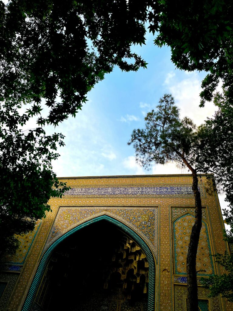 Historisches Gebäude mit Bögen in Isfahan, durch Bäume gesehen