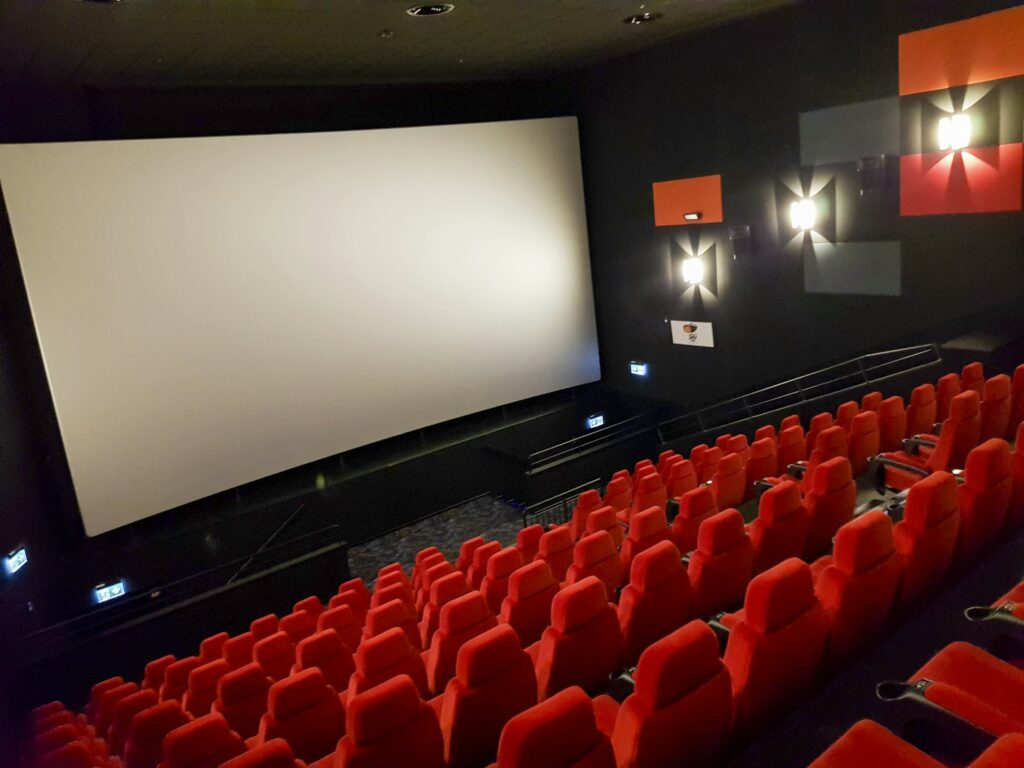 Leerer Kinosaal mit roten Sitzen und Leinwand